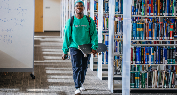 Young black man walking down the library